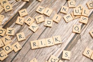 scrabble letters spelling risk on a wooden table